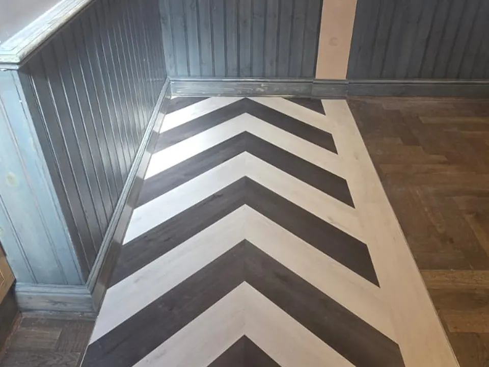 Black and white chevron feature strip with a light border running alongside wall panelling