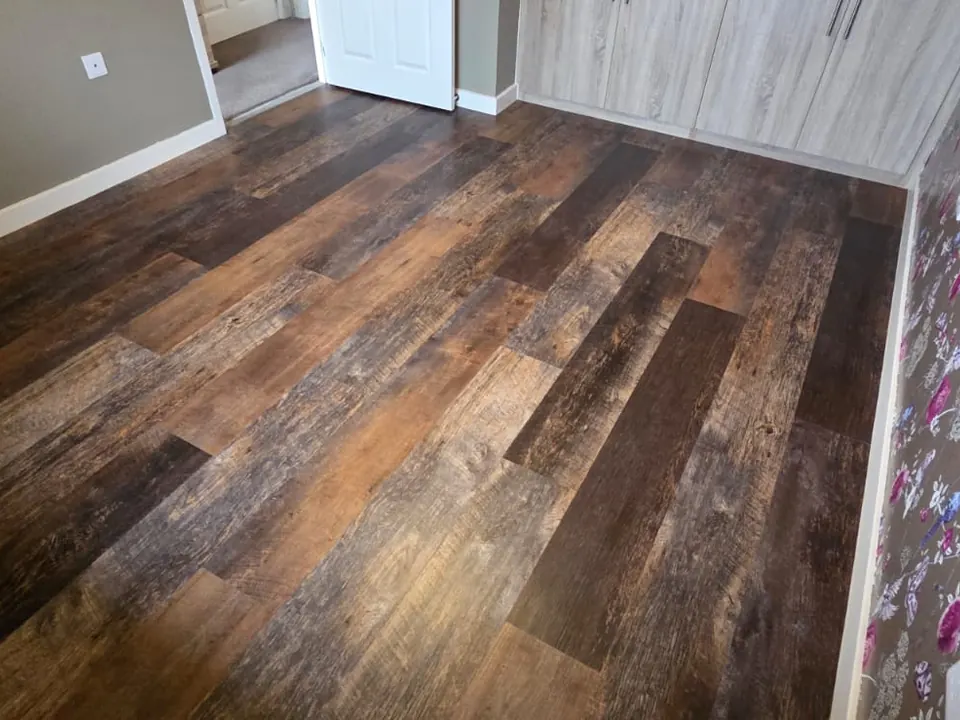 Rustic dark wood-effect LVT planks fitted in a bedroom
