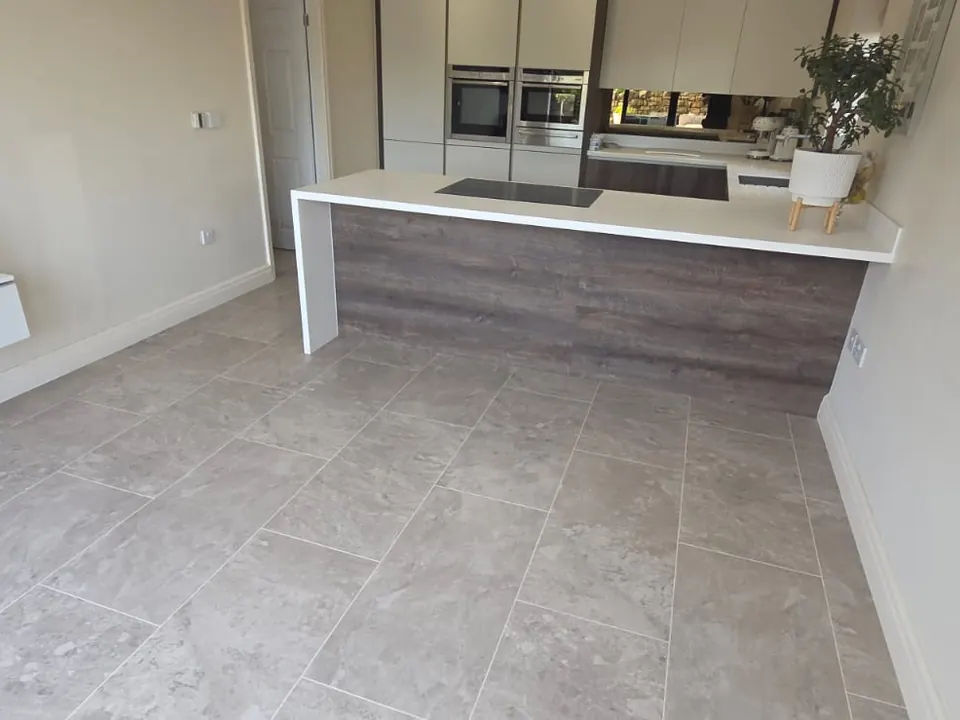 Grey stone-effect LVT tiles with grout lines in an open-plan kitchen