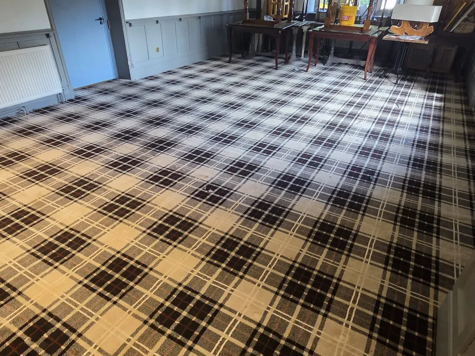 Black, white and red tartan carpet fitted across a large function room